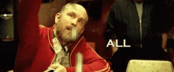 Man in red jacket throwing poker chips at table with text 'ALL'