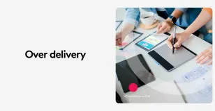 Digital designers collaborating using a tablet with design sketches and coffee.