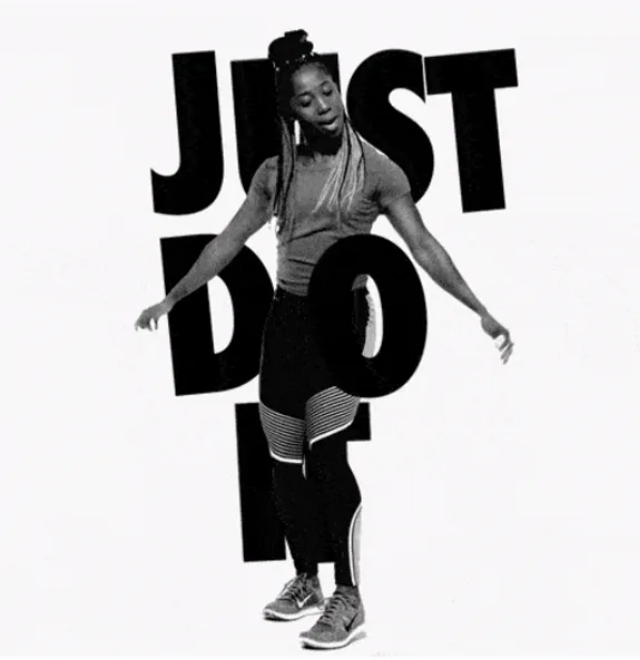 Woman in sporty attire dancing in front of 'Just Do It' text