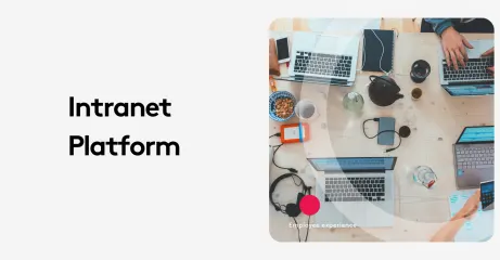 Top view of a work desk with laptops, phones, and office supplies for intranet platform.