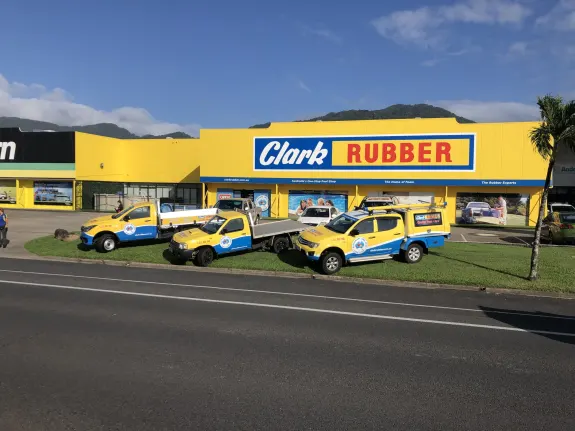 Clark Rubber storefront with yellow vehicles parked outside on a sunny day