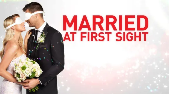 Blindfolded couple in wedding attire holding bouquet with 'Married at First Sight' text.