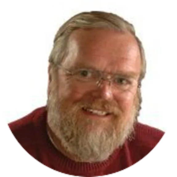 Man with glasses wearing a red sweater, smiling against white background.