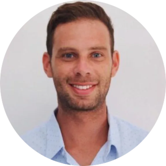 Smiling man in a blue shirt against a plain background
