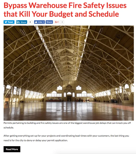 Interior view of a large empty warehouse with truss ceiling and polished floor.