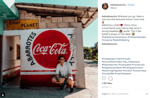 Man sitting outside a building with Coca-Cola logo painted on the wall in Mexico.