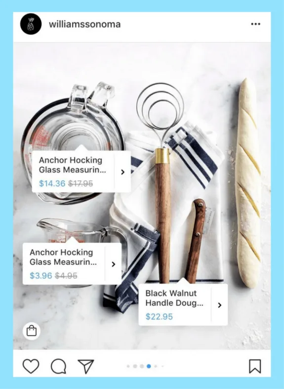 Kitchen tools including measuring cup, dough whisk, and bread on a cloth.