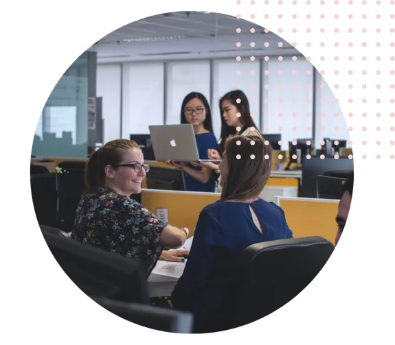 Team collaborating in a modern office with laptops and discussions.